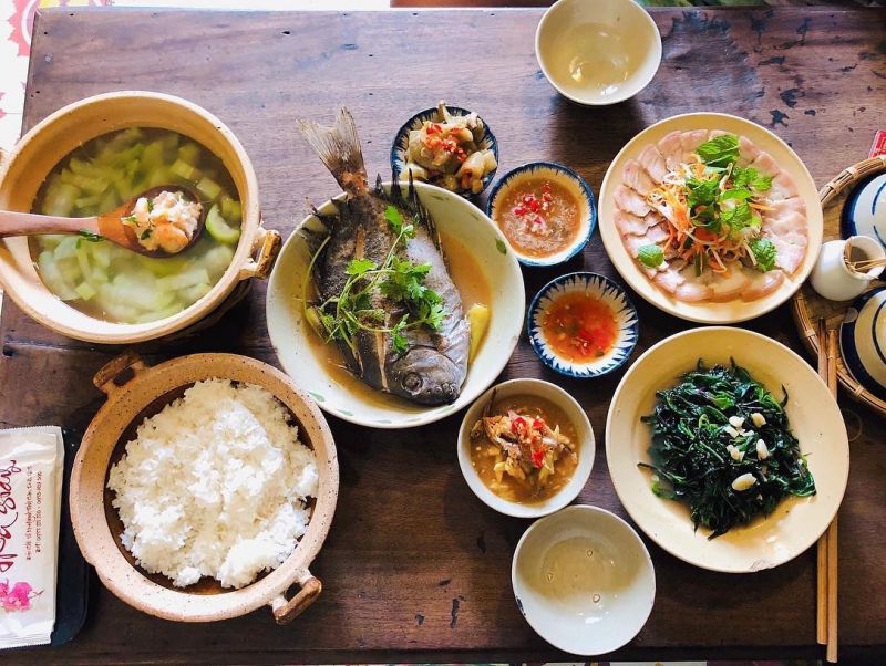 Set cơm tại Cafe Hoa Giấy gồm cơm sườn nướng, thịt kho mắm ruốc, canh khổ qua; phục vụ trong không gian nghệ thuật kiểu retro, kết hợp cà phê, đọc sách và ẩm thực truyền thống.