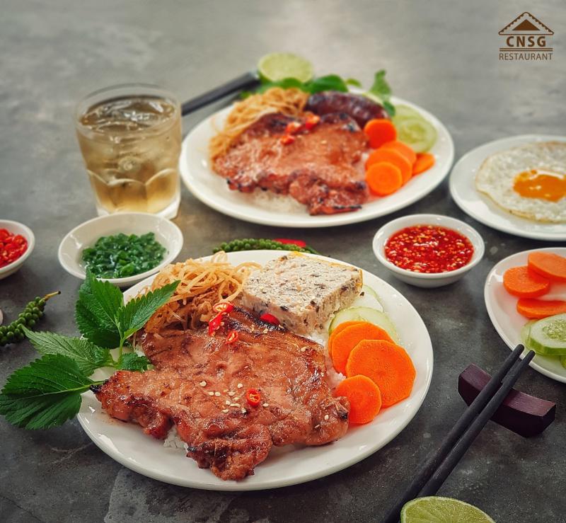 Phần cơm niêu tại Cơm Niêu Sài Gòn gồm cơm cháy cạnh niêu, cá nục kho cà, mực xào sa tế, canh rau ngót; được nấu bằng than và phục vụ trong niêu đất đúng kiểu ẩm thực truyền thống.