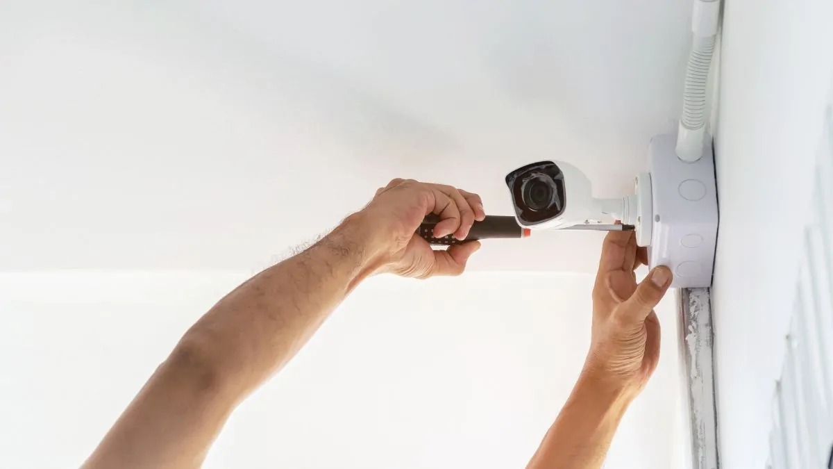 Kỹ thuật viên camera an ninh lắp hành lang nhà ở.