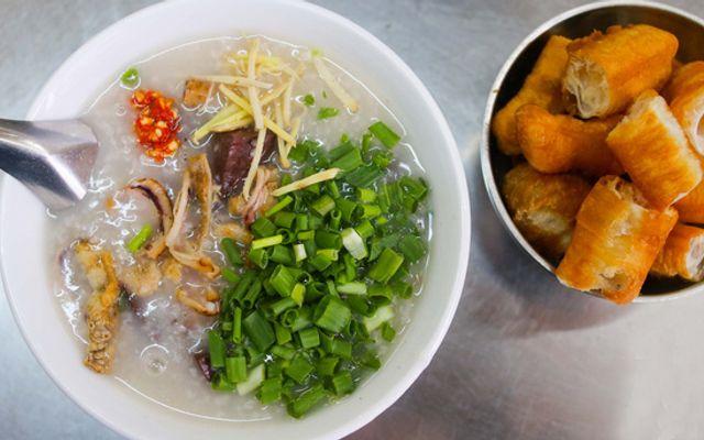 Tô cháo mực truyền thống với mực tươi, hành lá, gừng và ớt băm, ăn kèm quẩy giòn tại quán Thanh Sơn, Quận 1.