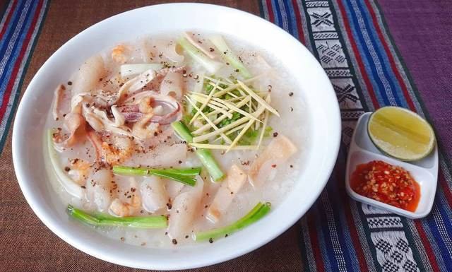 Tô cháo mực đầy đặn với mực tươi, hành lá, gừng sợi và tiêu đen, kèm chanh và ớt bằm – Quán Cô Mai, Quận 1, TP.HCM.