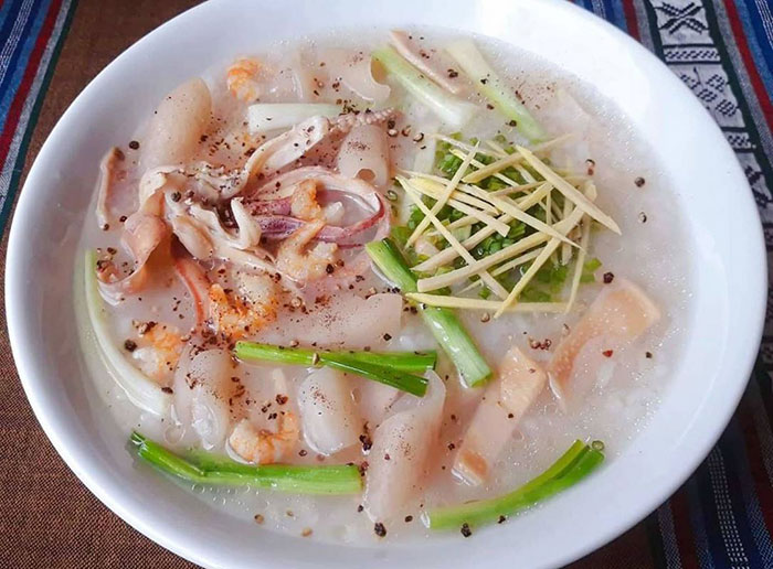 Tô cháo mực gia truyền với mực tươi, hành lá, gừng sợi và tiêu đen – Quán Cô Năm tại TP.HCM.