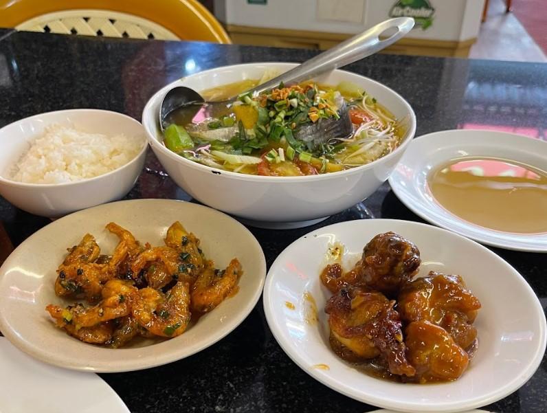 Suất cơm văn phòng Quán Cơm Hạnh Thu đóng hộp nhựa PET hoặc khay nhôm, gồm món mặn, rau, canh nóng; phục vụ đồng loạt cho công ty từ 200 phần trở lên, có hợp đồng dài hạn.