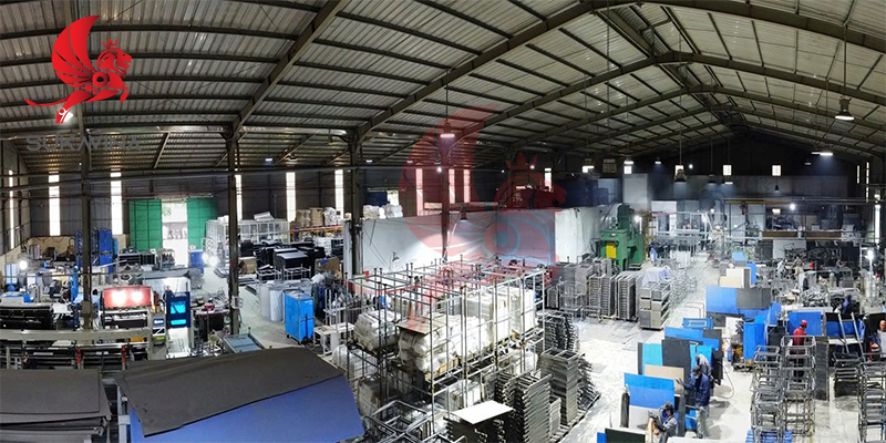 Toàn cảnh nhà xưởng Trường Việt với dãy máy móc, kệ giá kim loại và khu vực lắp ráp thiết bị ngành may.