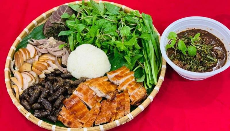 Mâm đồ ăn truyền thống gồm thịt quay, dồi nướng, lòng luộc, cơm nếp, rau rừng và chẳm chéo, được bày biện tinh tế trên mẹt tre – một phần của thực đơn đặc sản núi rừng theo phong cách hiện đại tại Sky Restaurant.