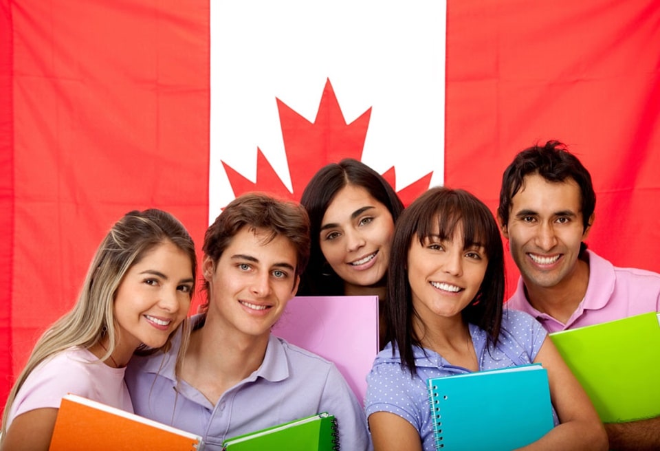 Hình ảnh một nhóm du học sinh trẻ trung, năng động với lá cờ Canada phía sau, thể hiện tinh thần sẵn sàng cho hành trình học tập tại xứ sở lá phong. Hình ảnh minh họa cho bài viết giới thiệu các công ty tư vấn du học Canada uy tín tại TP.HCM.