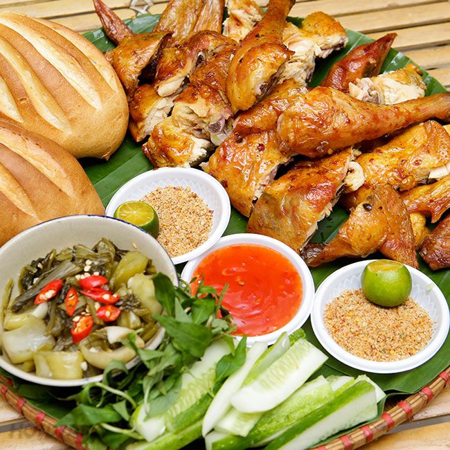 Mâm gà nướng Cái Bang gồm gà tơ nướng muối ớt, xôi chiên, gỏi lòng, rau rừng và chén nước chấm ớt xiêm, bày trí phong cách kiếm hiệp.

