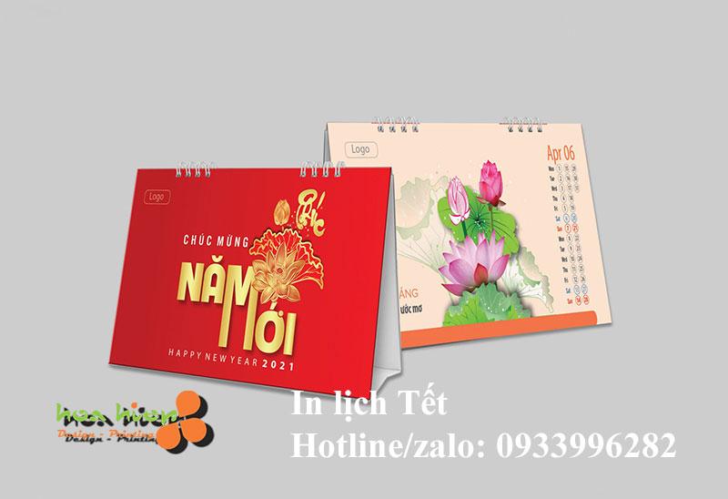 Hai cuốn lịch bàn Hòa Hiệp: bìa đỏ chữ vàng “Chúc mừng năm mới 2021” và trang tháng 4 in lịch Tết hoa sen, kèm thông tin hotline in lịch Tết.