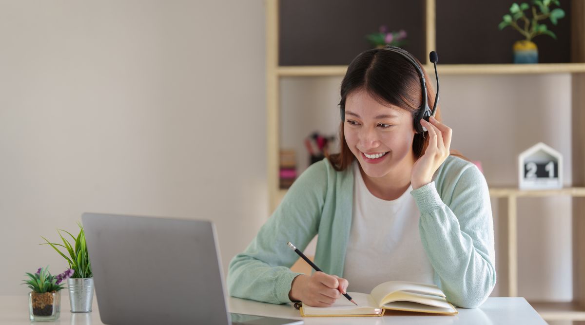 Nữ sinh viên đeo tai nghe học khóa học online