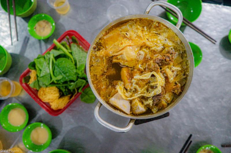 Lẩu bò Nghĩa Địa với gầu bò mềm, xí quách béo, nước dùng đậm vị miền Nam, phục vụ buổi chiều tối trong không gian đặc biệt cạnh nghĩa trang cũ.