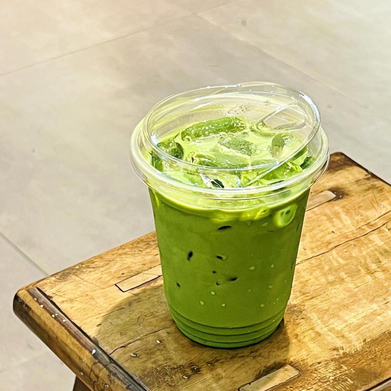 Cận cảnh một ly matcha đá Avocat màu xanh tươi trên bàn gỗ vintage tại TP.HCM.