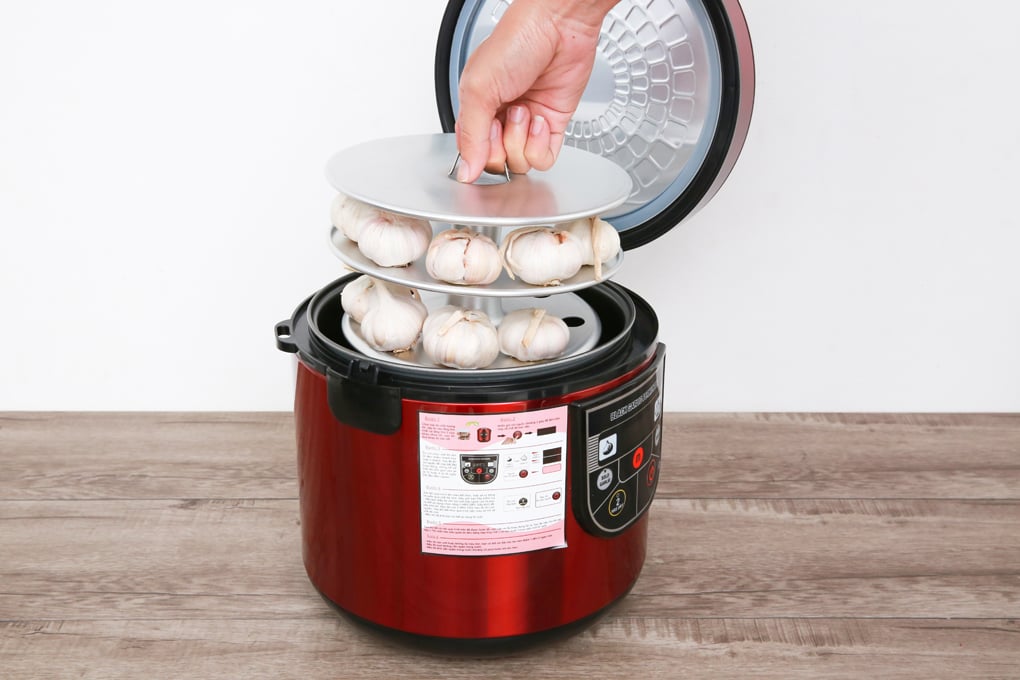 Thao tác xếp khay tỏi trắng vào máy làm tỏi đen màu đỏ để bắt đầu quy trình lên men tự động tại nhà.