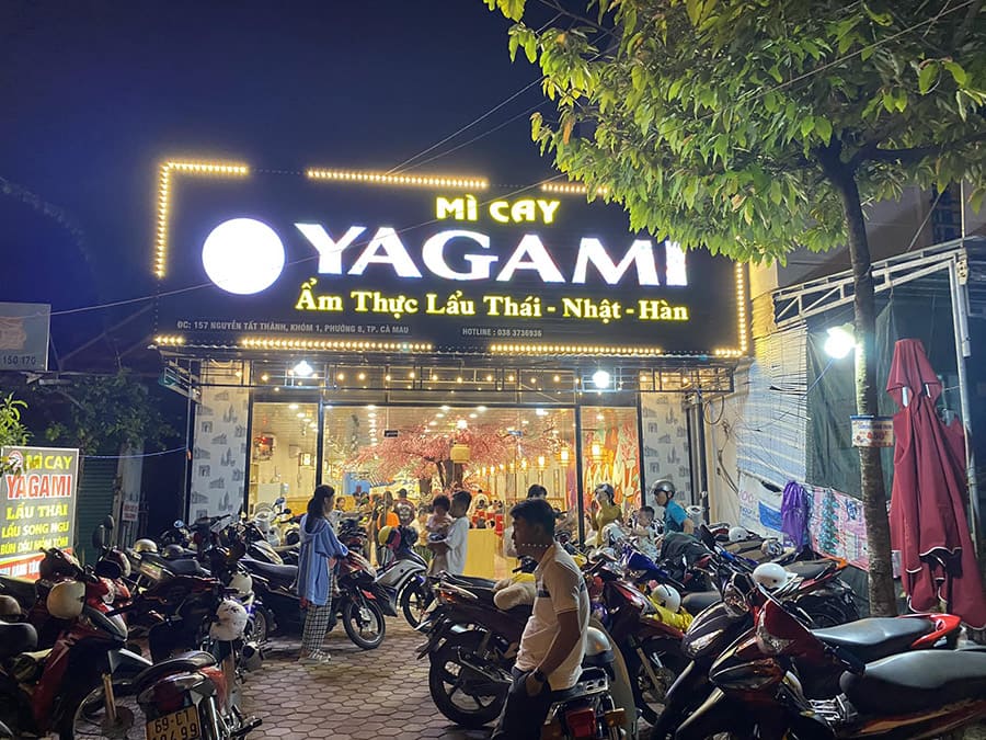 Mặt tiền quán mì cay Yagami tại Cà Mau, bảng hiệu đèn LED nổi bật, đông khách buổi tối.