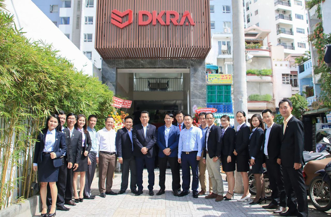 Nhân viên công ty DKRA chụp ảnh trước trụ sở tại TP.HCM, đại diện cho đơn vị môi giới bất động sản uy tín và chuyên nghiệp.