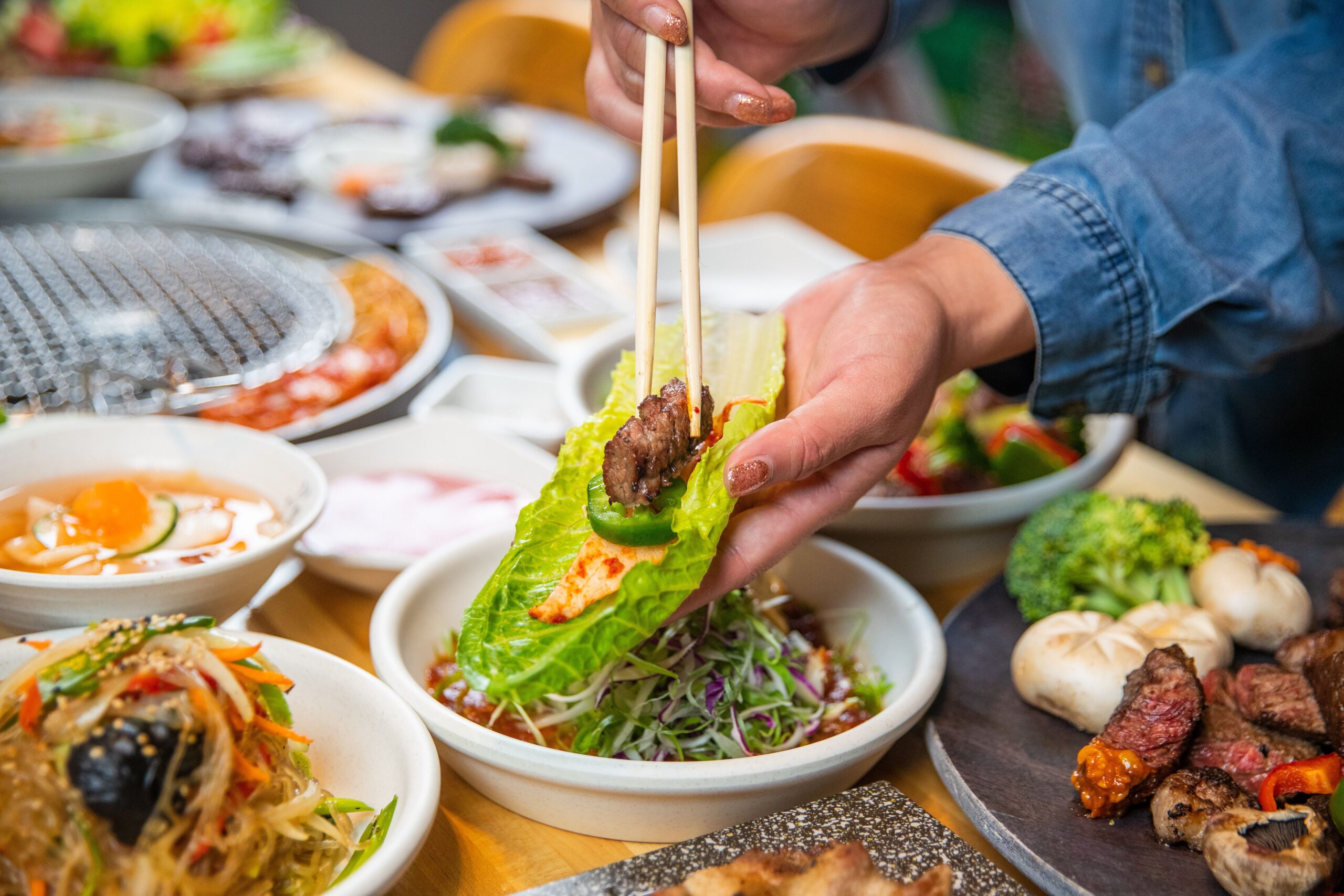 Thực khách gắp thịt nướng cuốn rau xà lách chấm ssamjang chuẩn vị Hàn Quốc