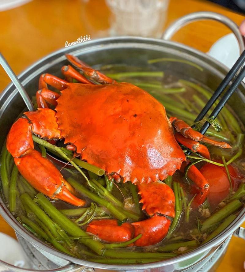 Nồi lẩu cua với cua nguyên con và rau muống xanh tươi – món đặc sản nổi bật tại Lẩu Cua Đất Mũi, nổi tiếng với nước dùng ngọt thanh đậm chất miền Tây.