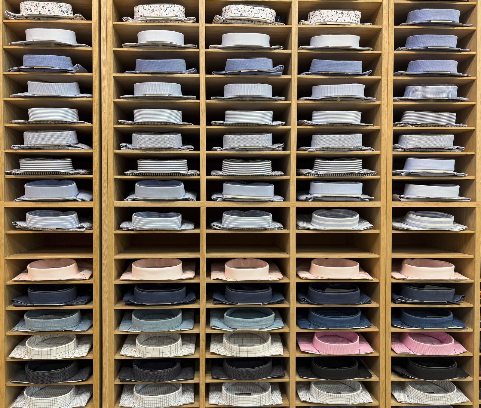 Áo sơ mi nam được xếp gọn trên kệ gỗ tại shop quần áo nam đẹp Quận 1