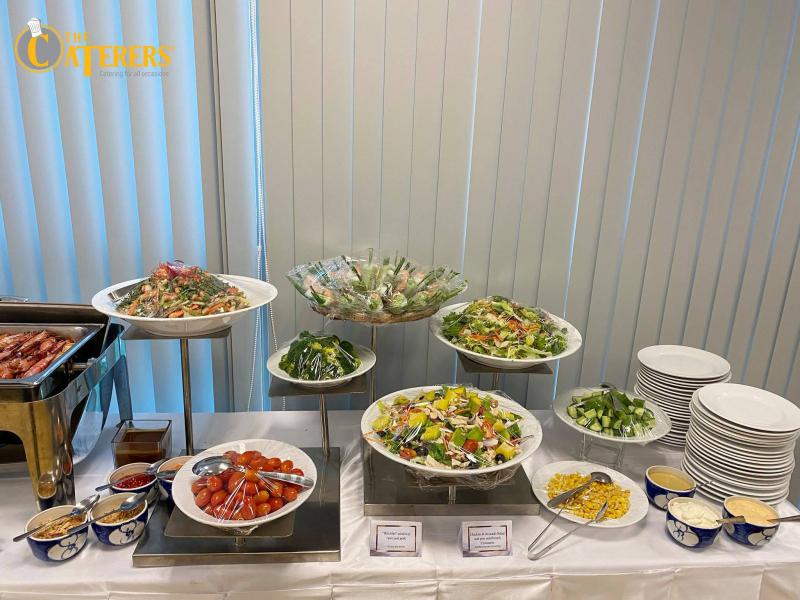 Hình ảnh đầu bếp The Caterers chuẩn bị bữa trưa học đường với quy trình nghiêm ngặt, thể hiện sự chuyên nghiệp trong cung cấp suất ăn trường học.