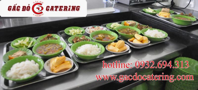 Hình ảnh nhân viên Gấc Đỏ đóng gói bữa ăn học đường trong khu bếp sạch sẽ, thể hiện quy trình cung cấp suất ăn trường học an toàn và chuyên nghiệp.