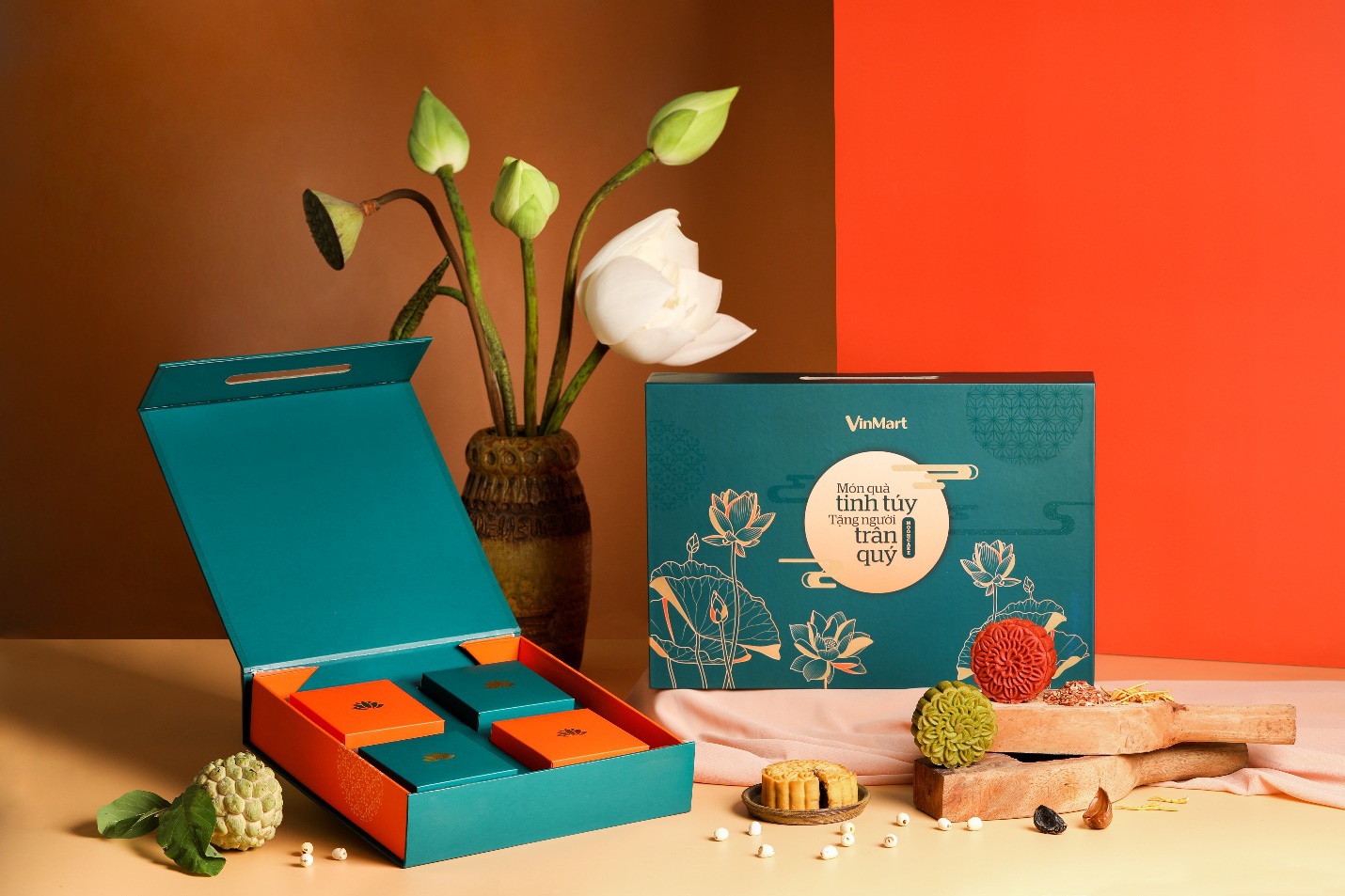 Hộp bánh Trung Thu VinMart màu xanh ngọc sang trọng với thiết kế tinh tế, gồm nhiều ngăn đựng bánh, trang trí hoa sen và thông điệp tặng người trân quý.