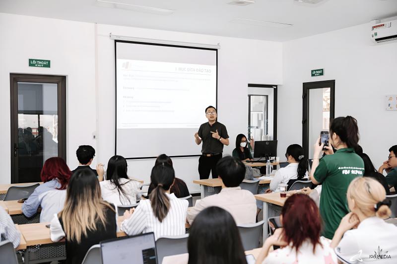 “Giảng viên FPT Telecom trình bày trước lớp sinh viên tại phòng học hiện đại; màn chiếu hiển thị slide mục tiêu đào tạo, minh họa chương trình thực tập kỹ sư mạng & phát triển phần mềm.”