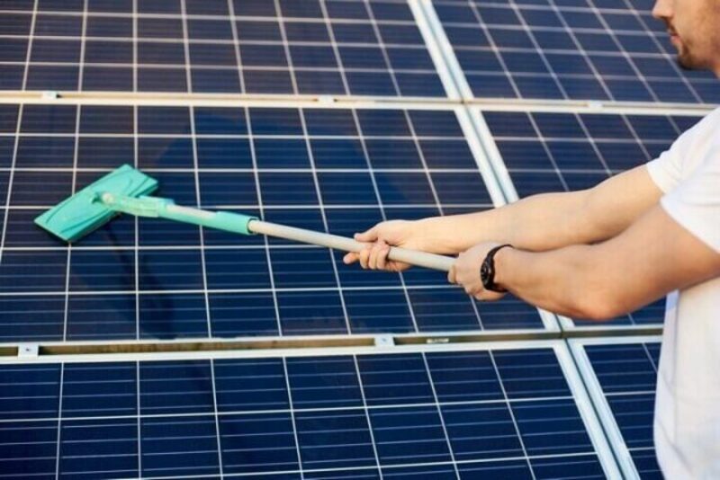 Dùng cây lau chuyên dụng vệ sinh tấm pin năng lượng mặt trời