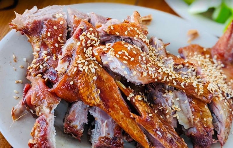 Dĩa vịt quay kiểu Hoa được cắt nhỏ, da giòn vàng ươm, phủ mè trắng, bày trên đĩa trắng tại quán Huyền Vịt – Gò Vấp.