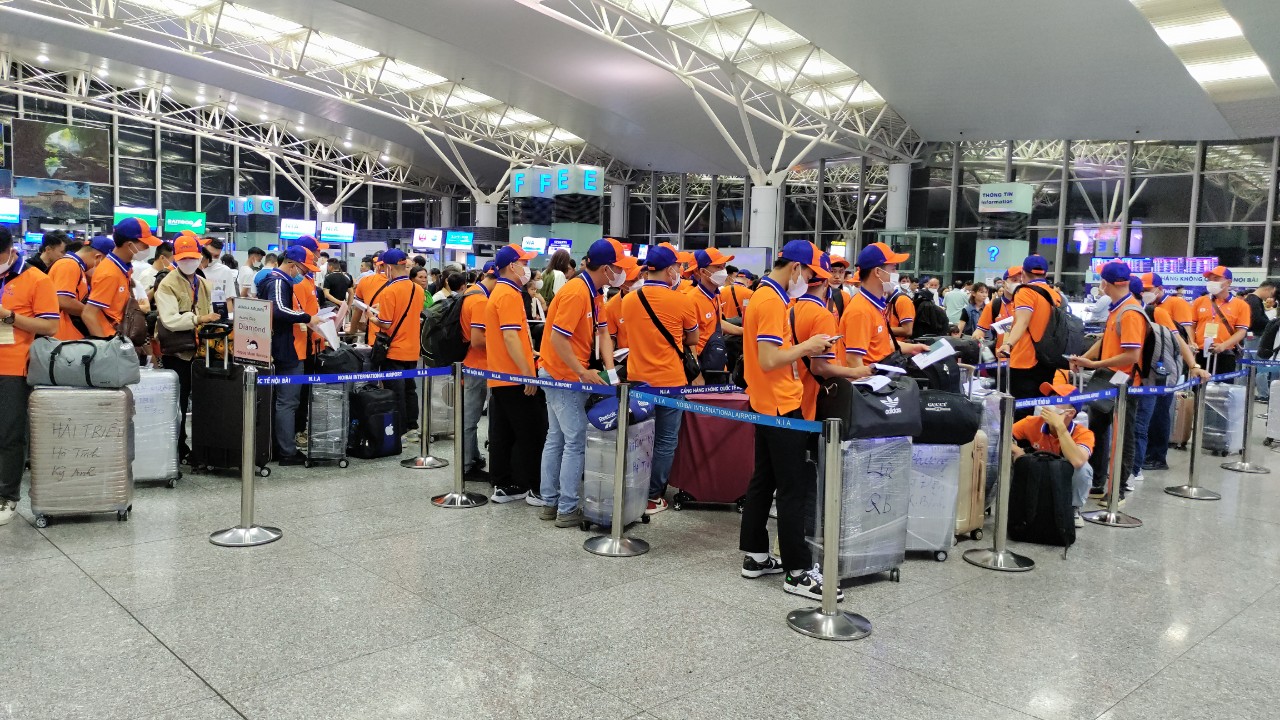 Lao động Tracimexco mặc đồng phục cam tại sân bay Nội Bài, chuẩn bị xuất cảnh sang Hàn Quốc.